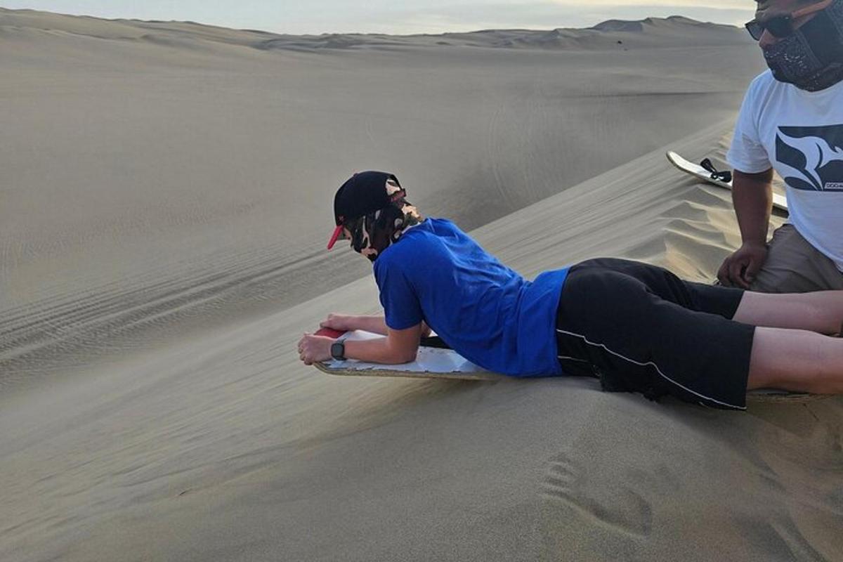 a person laying on a surfboard in the desert