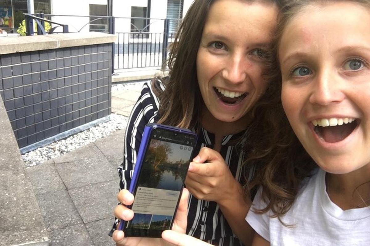 dve ženski držita mobilni telefon