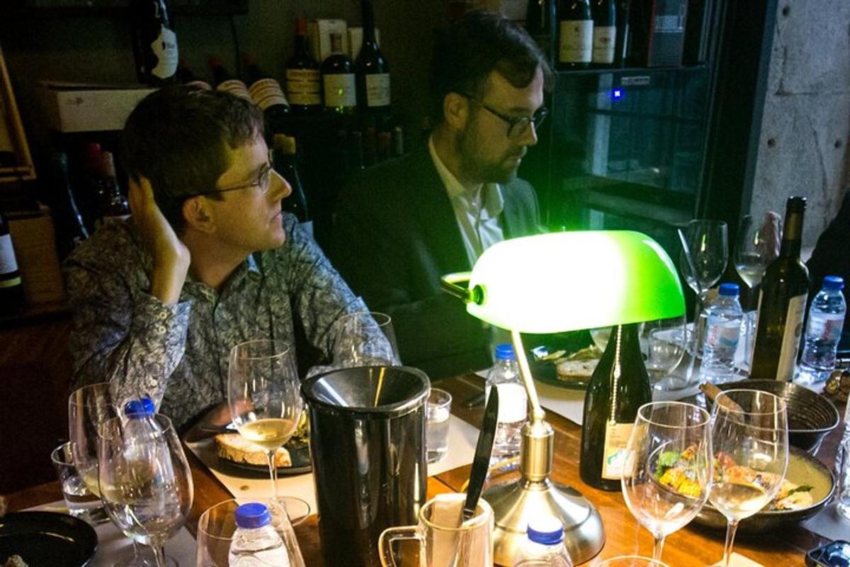 dois homens sentados à mesa com taças de vinho