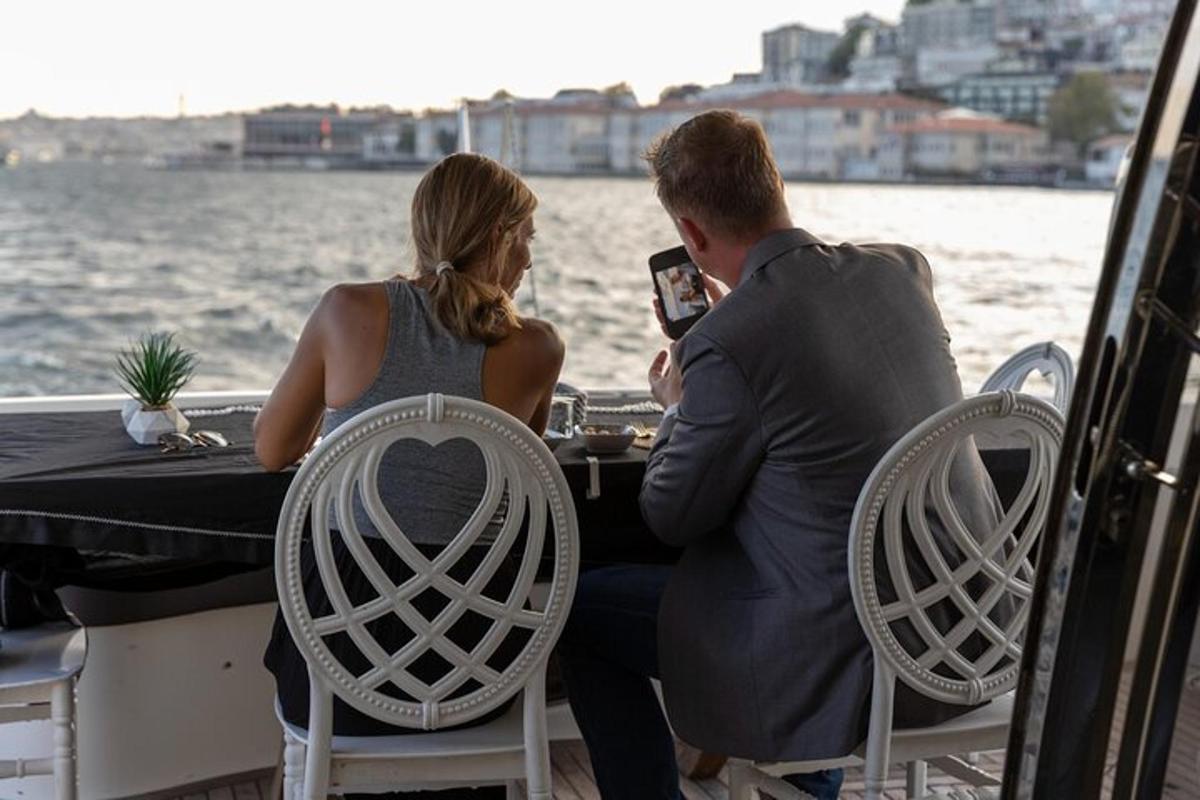 ένας άντρας και μια γυναίκα κάθονται σε ένα τραπέζι σε μια βάρκα