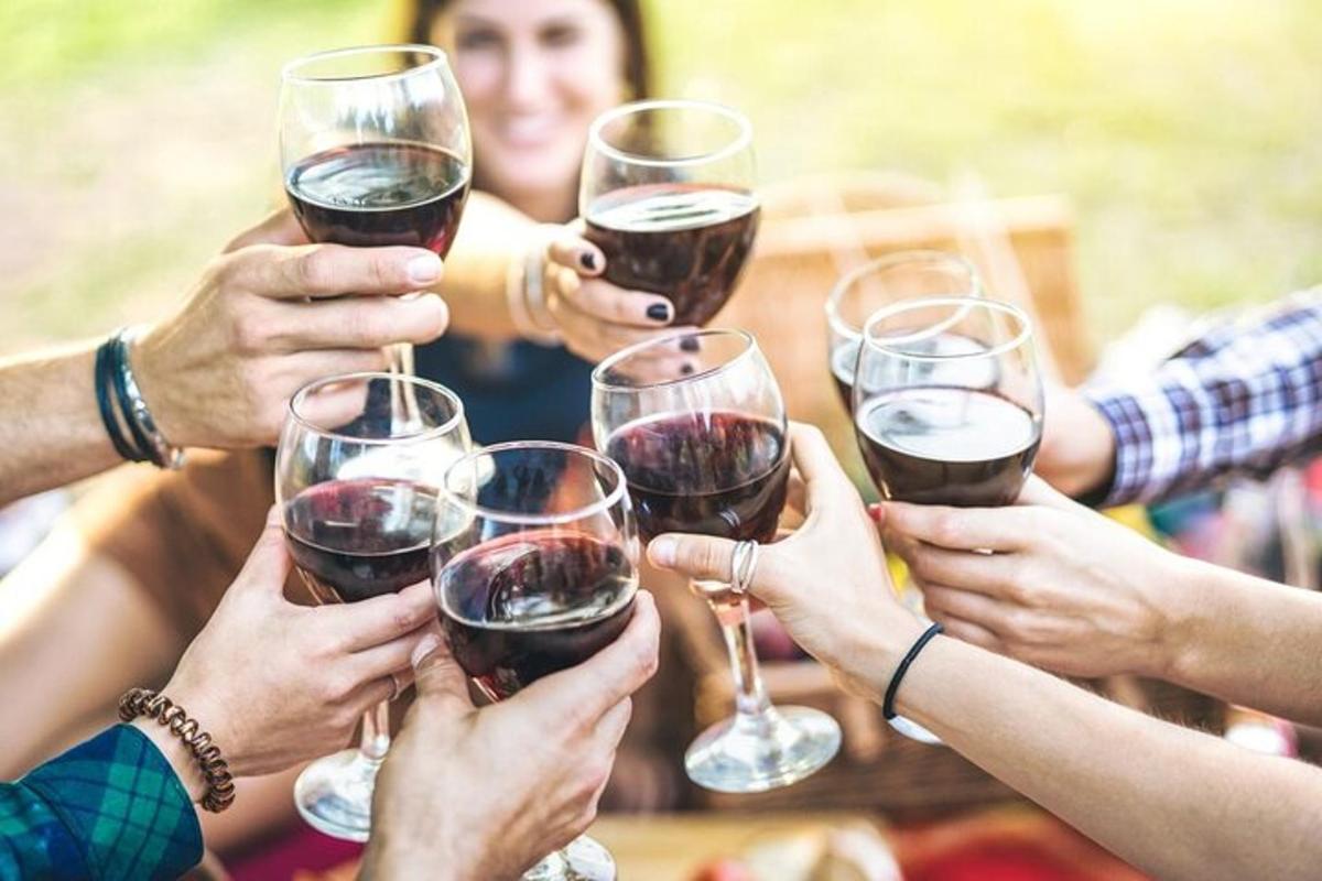 un gruppo di persone che sorreggono bicchieri di vino
