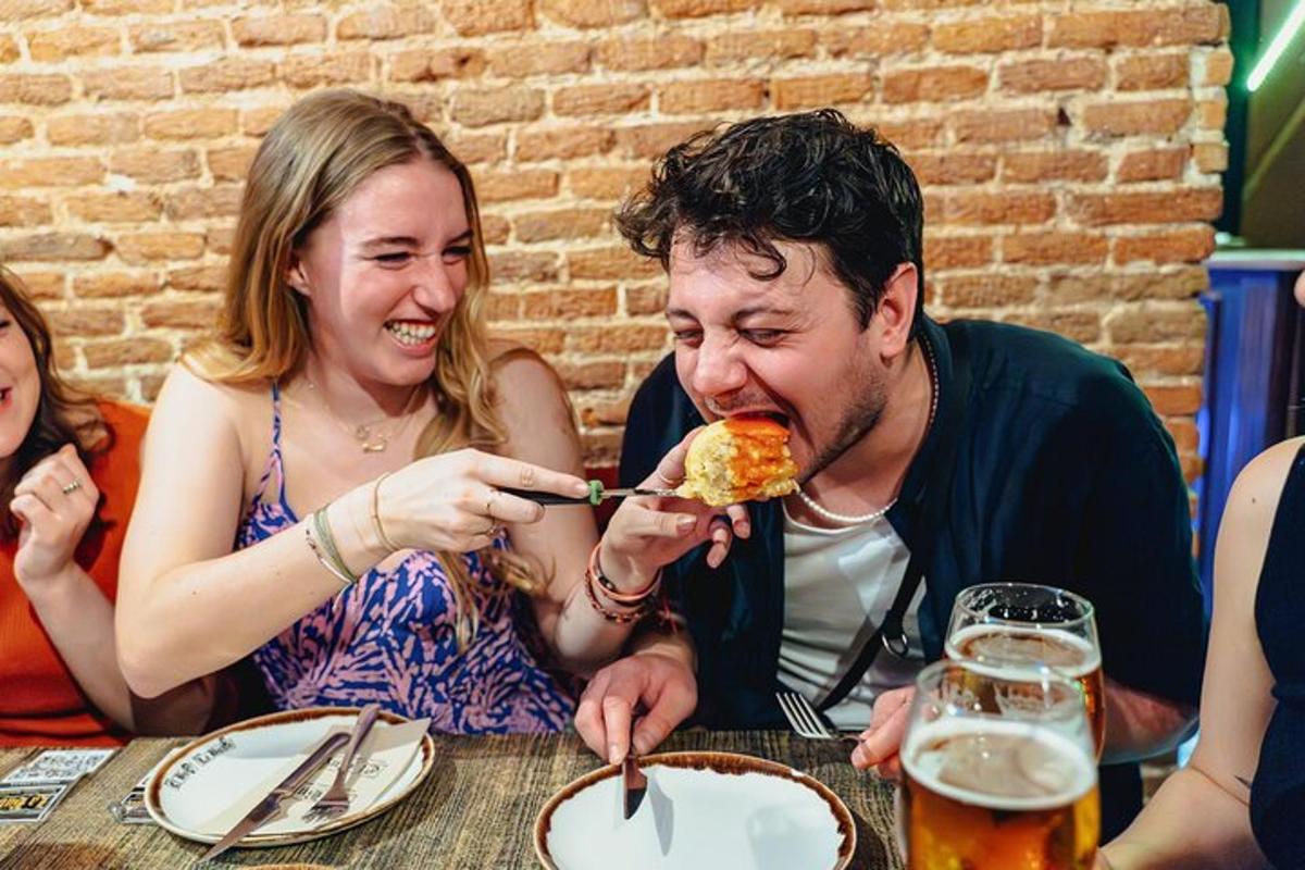 moški in ženska sedita za mizo in jesta pico