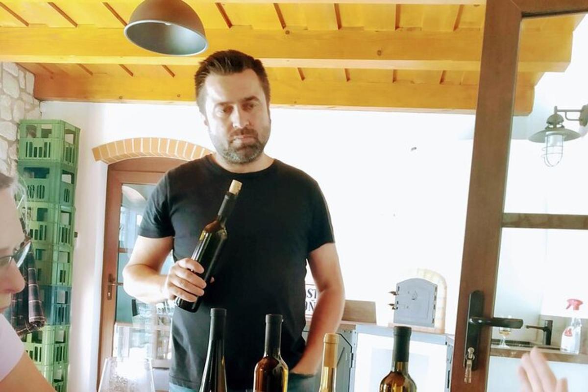 a man is holding a bottle of wine