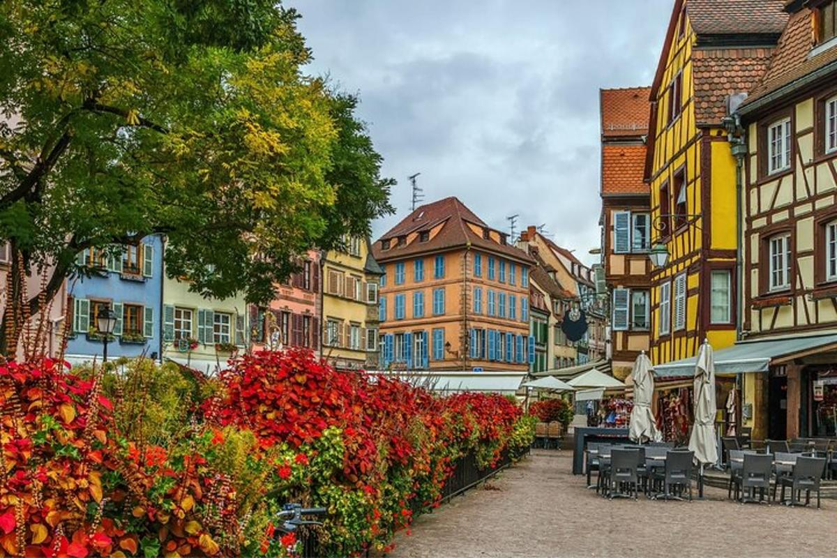una strada cittadina con edifici, sedie e fiori