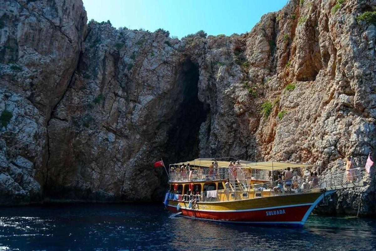 a boat in the water in front of a cliff