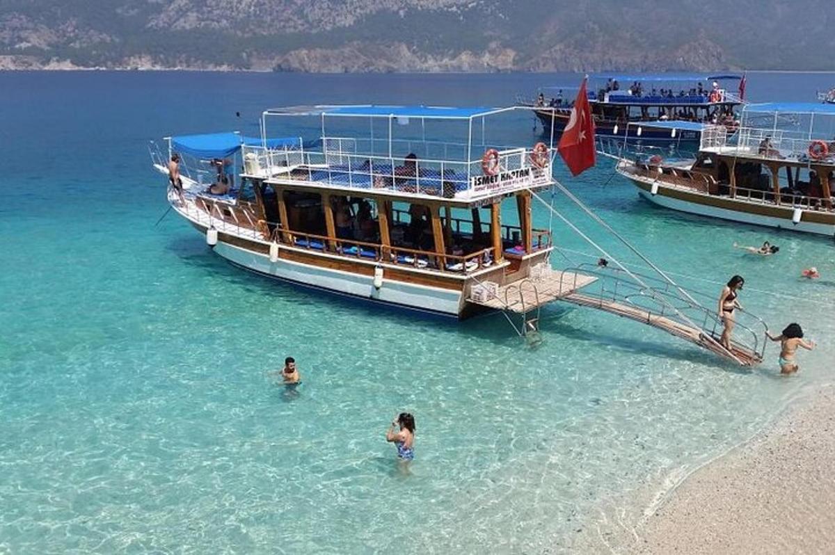 a boat in the water next to people in the beach