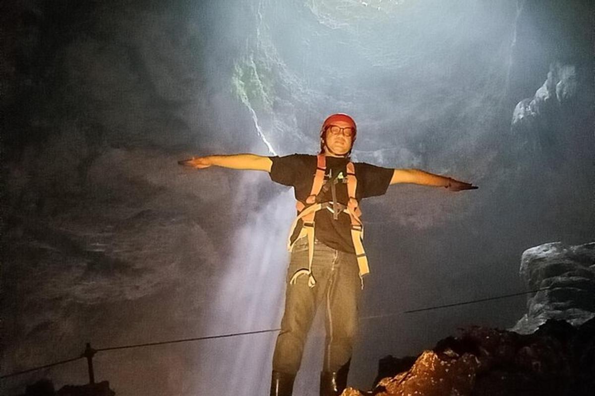 seorang lelaki berdiri di atas wayar dengan tangan dihulurkan
