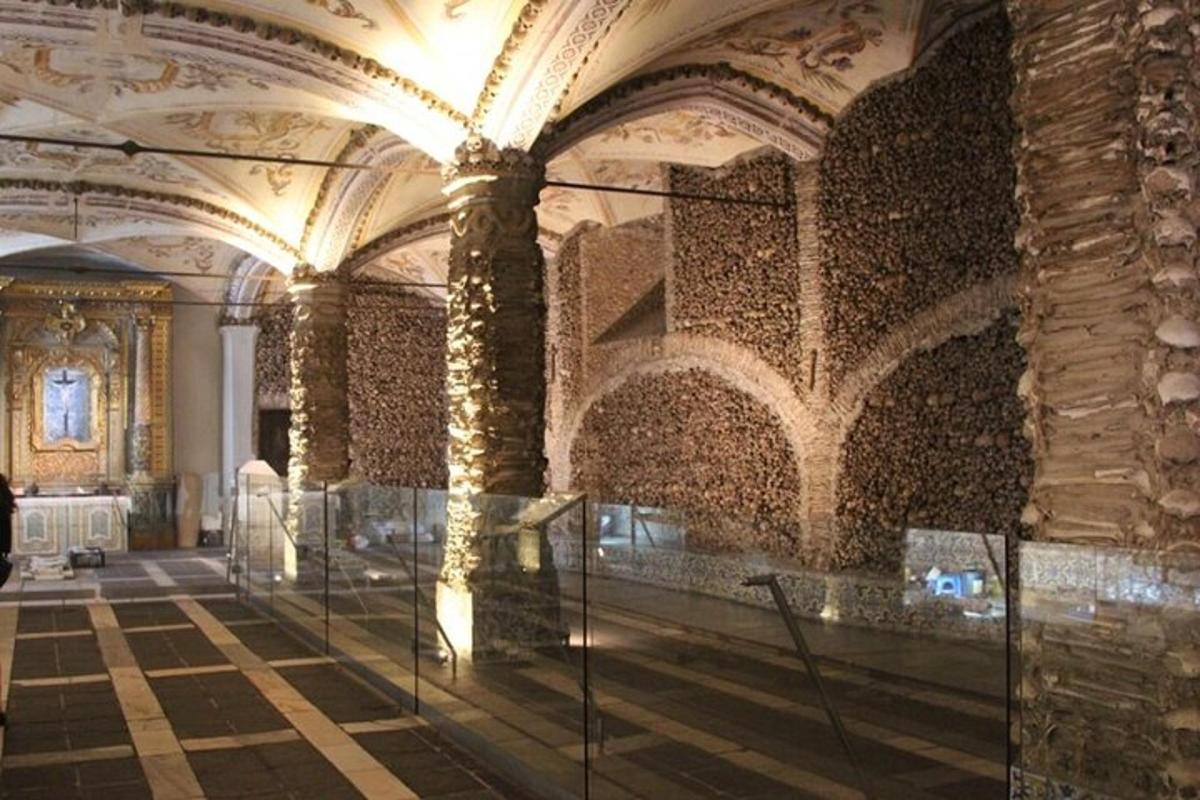 una gran sala amb una paret de pedra i columnes