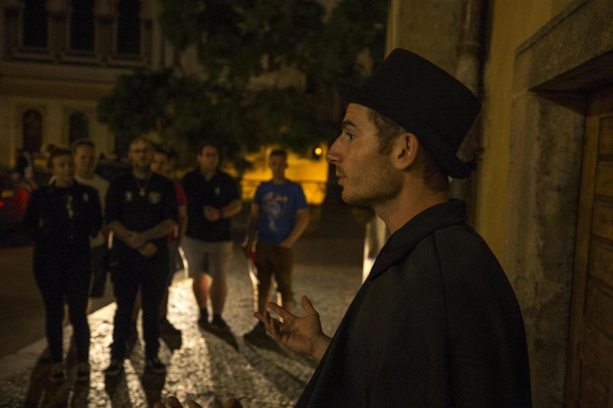 un uomo che indossa un cappello nero in piedi su una strada