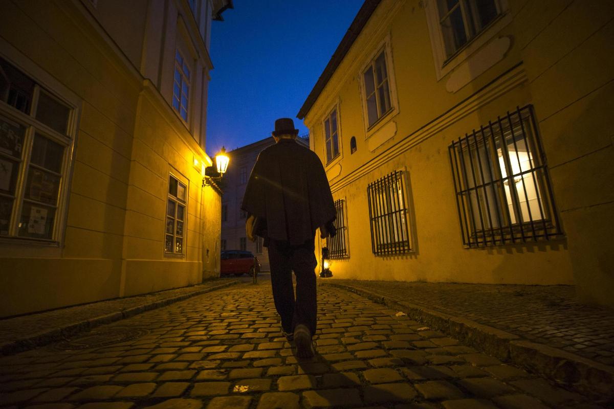 un uomo che cammina per strada di notte