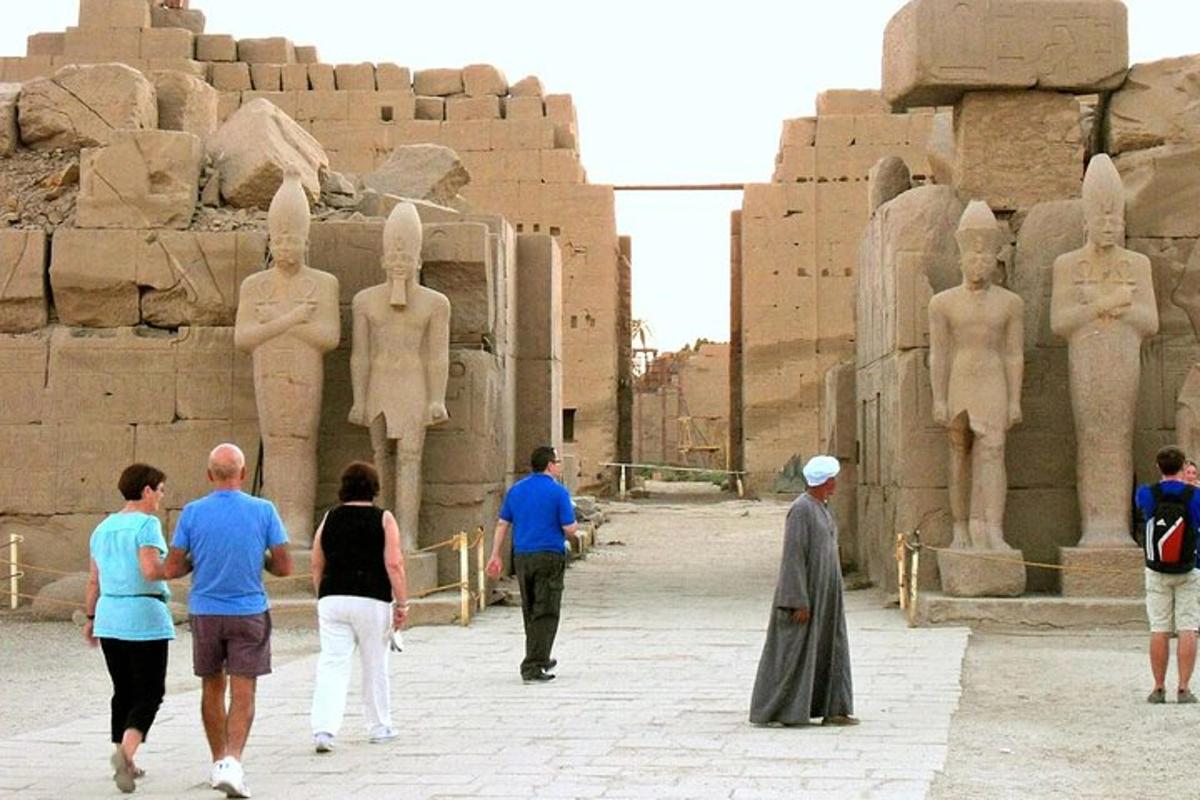 a group of people walking in front of a statue