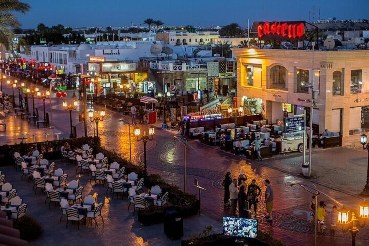 μια ομάδα ανθρώπων που στέκονται γύρω από έναν δρόμο της πόλης τη νύχτα
