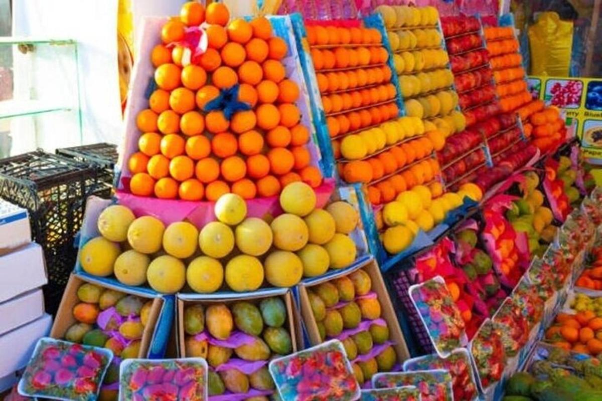 Una exhibición de naranjas y otras frutas en una tienda.