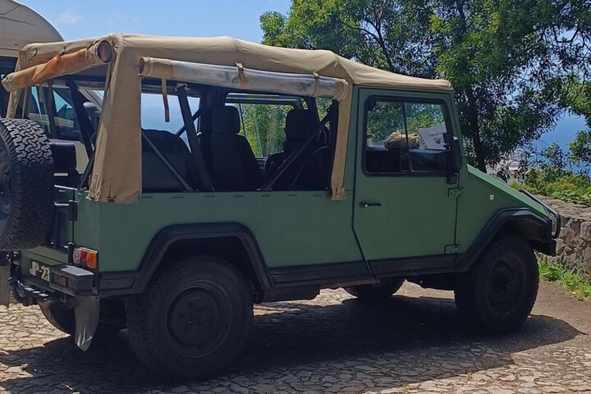 un jeep verde estacionado en un camino de tierra