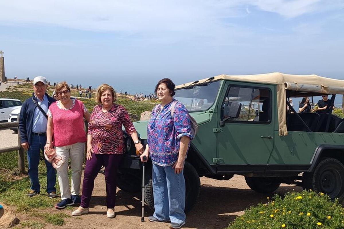 Un grupo de personas de pie junto a un vehículo verde.