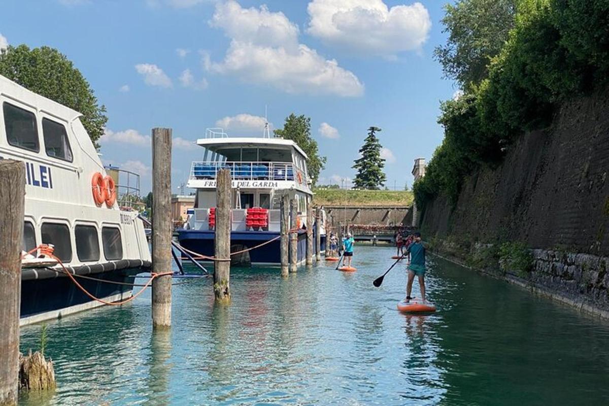 skupina lidí na paddleboardech v řece s lodí