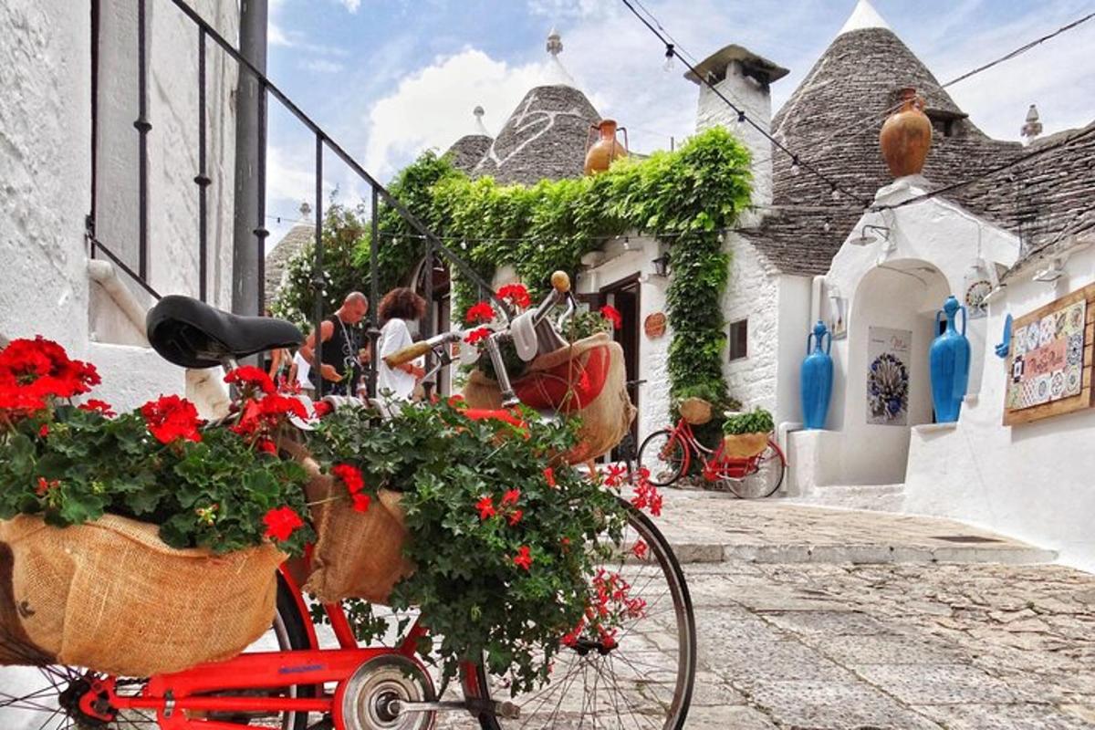 a red bike parked next to a building with flowers