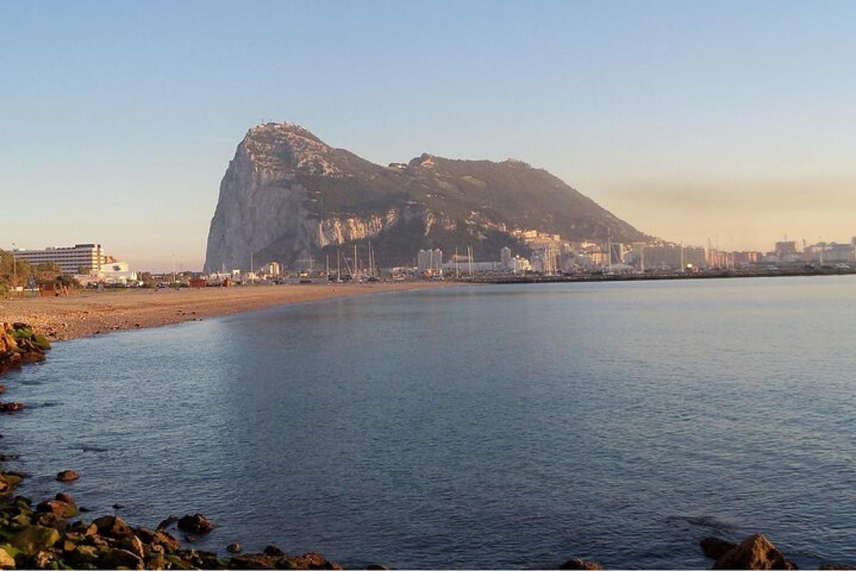 Una vista de una playa con una montaña al fondo.