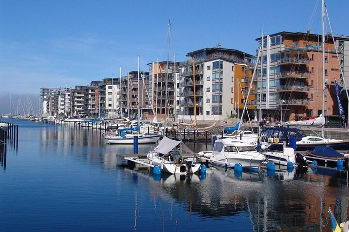 hópur báta sem liggja að bryggju í smábátahöfn með byggingum