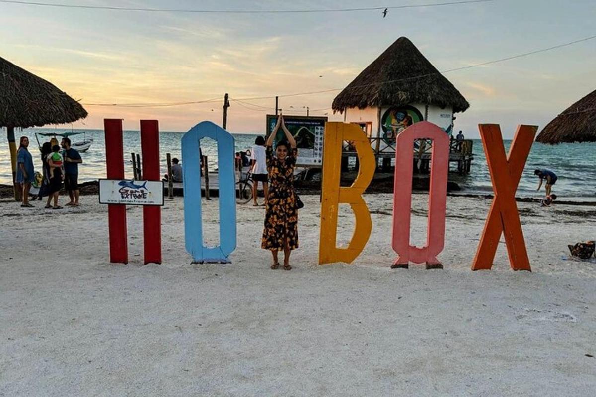 uma mulher parada em frente a uma placa na praia