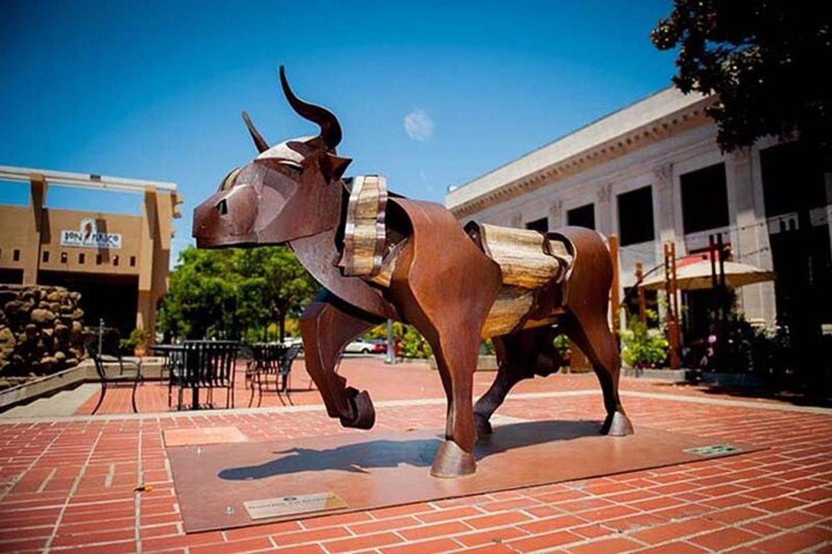 a statue of a cow running in front of a building