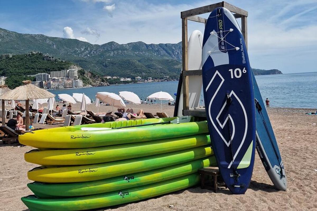 un mucchio di tavole da surf su una spiaggia vicino all'acqua