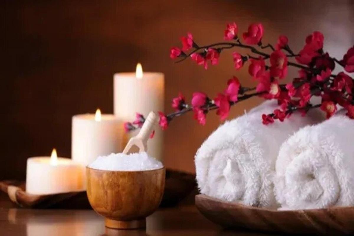 un tavolo con candele, un asciugamano e fiori
