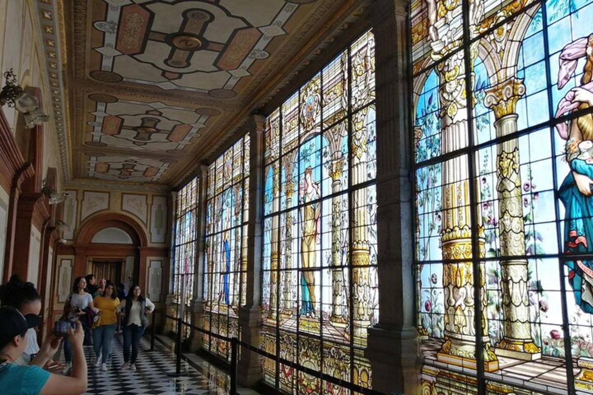 people taking pictures of a large stained glass wall