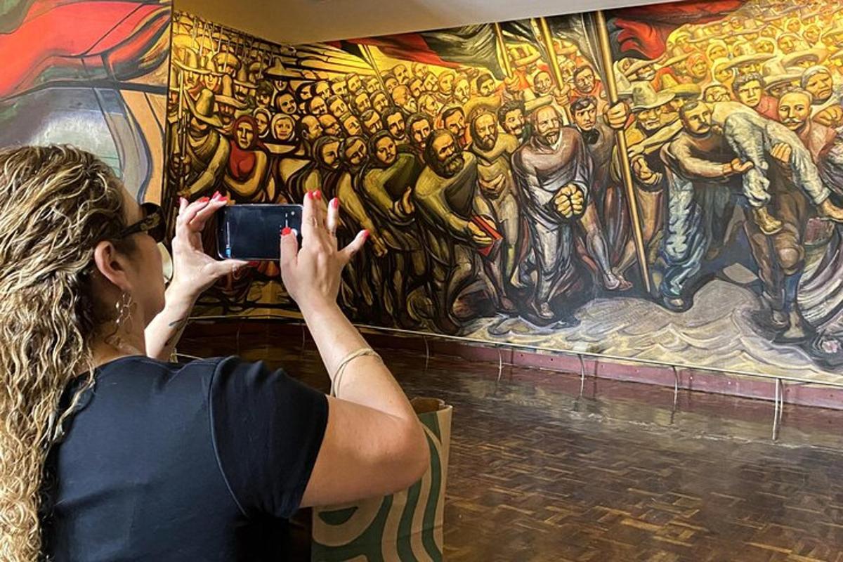 a woman taking a picture of a painting