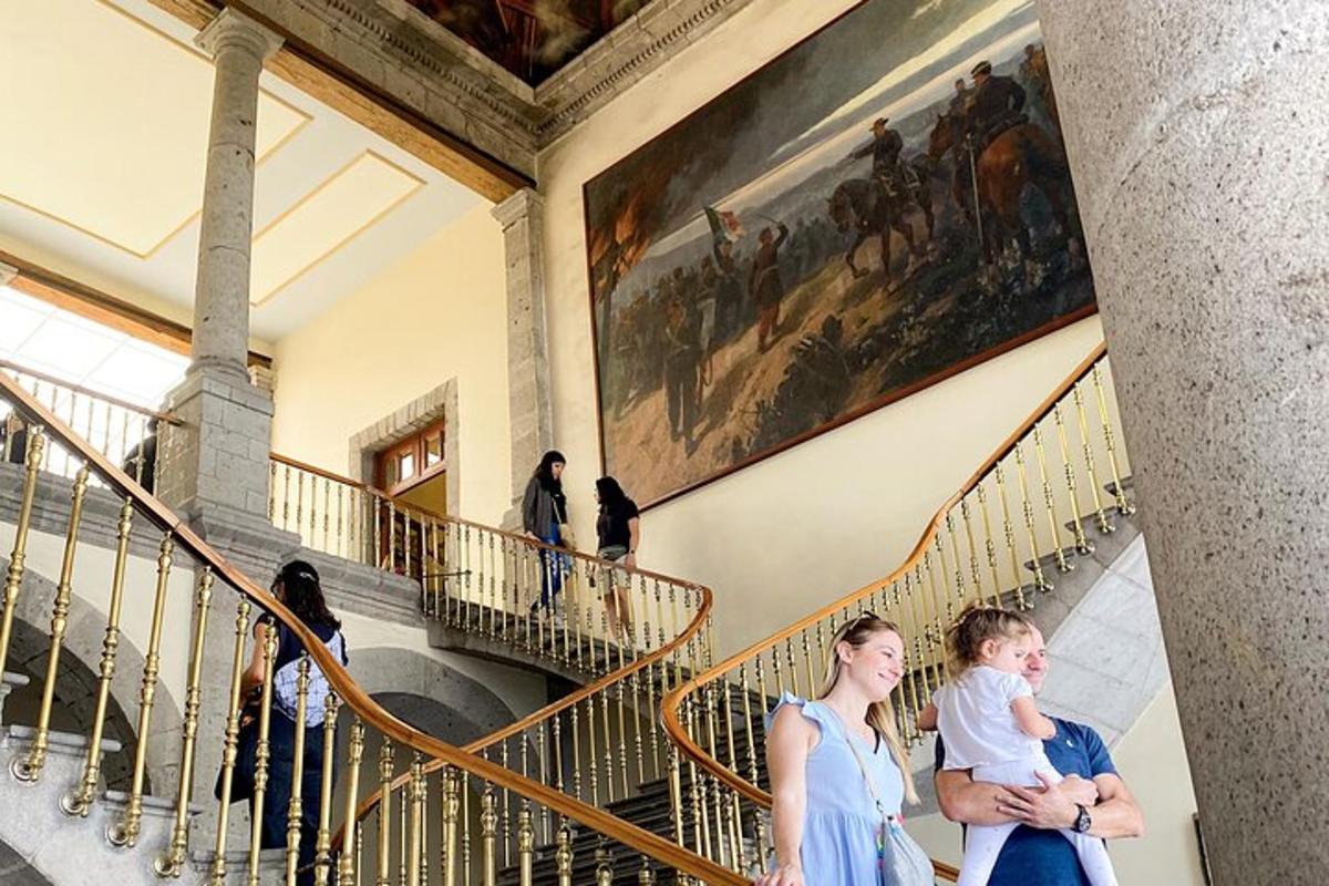a woman holding a baby in front of a painting in a museum