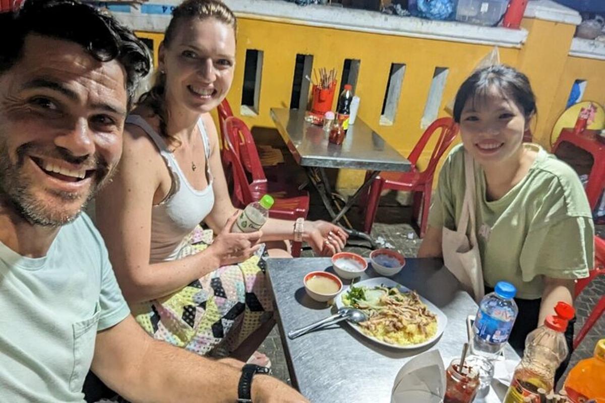 un gruppo di persone sedute a un tavolo che mangiano cibo