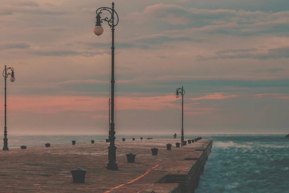 una fila di luci su un molo vicino all'oceano