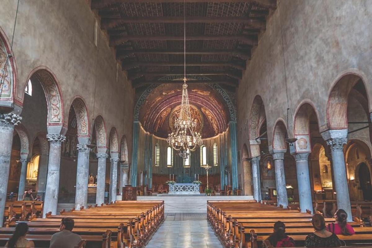 un gruppo di persone sedute in una chiesa con un lampadario