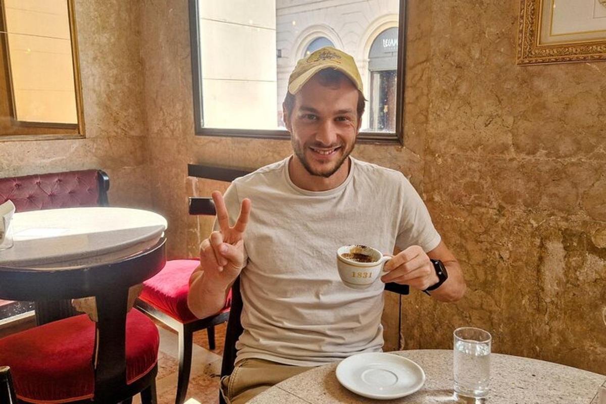 um homem sentado à mesa com uma xícara de café