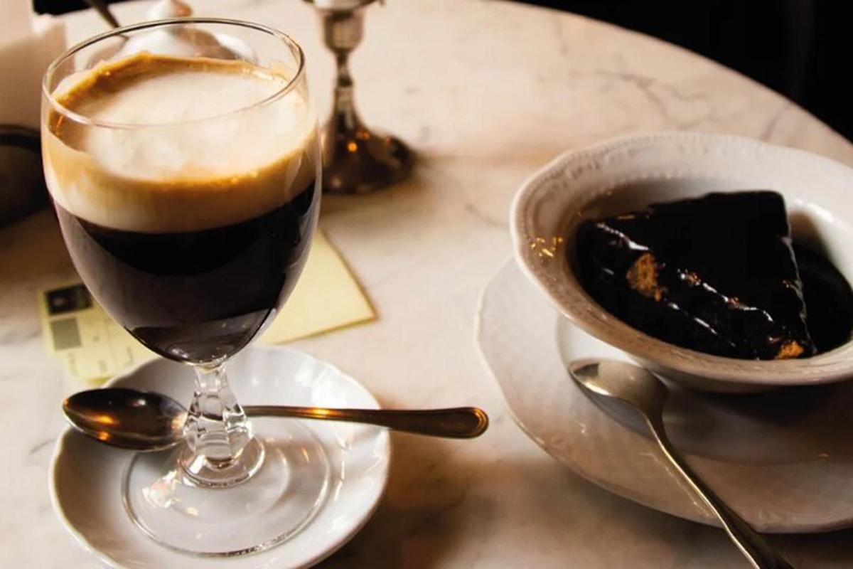 a glass of coffee and a bowl of cake on a table
