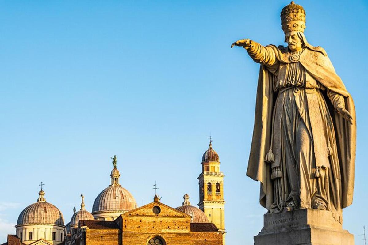uma estátua em frente a um prédio com uma torre de relógio
