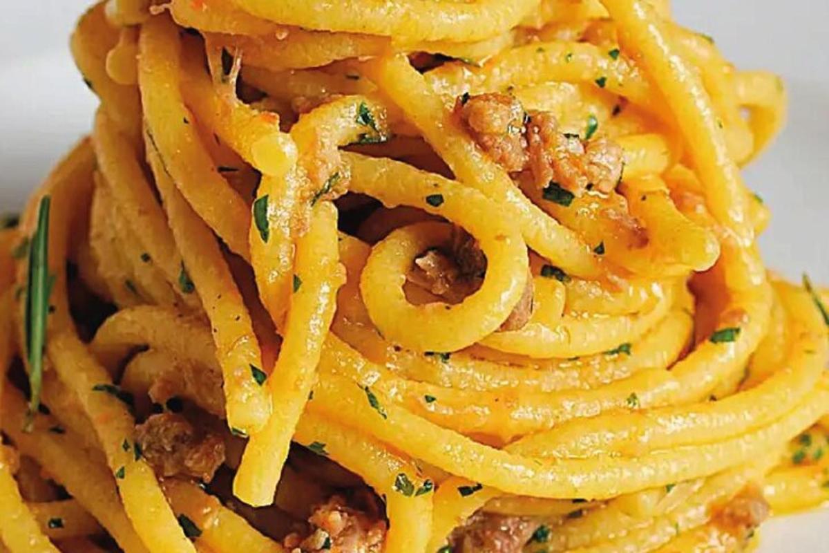 uma pilha de macarrão com carne e queijo em um prato