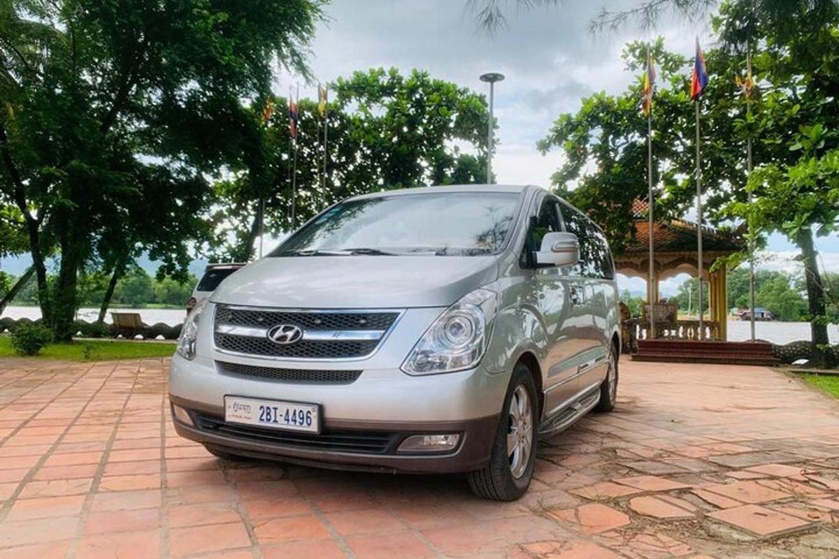 um carro prateado estacionado em uma entrada de tijolos