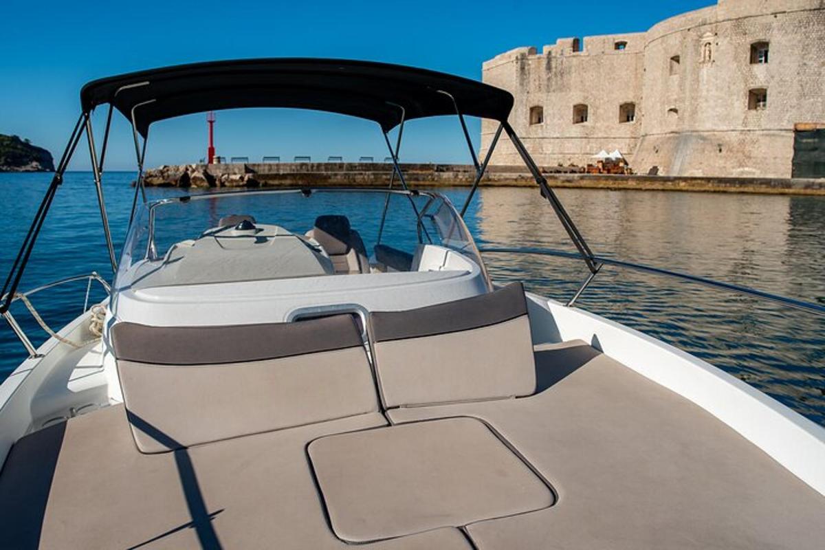 a white boat in the water near a castle