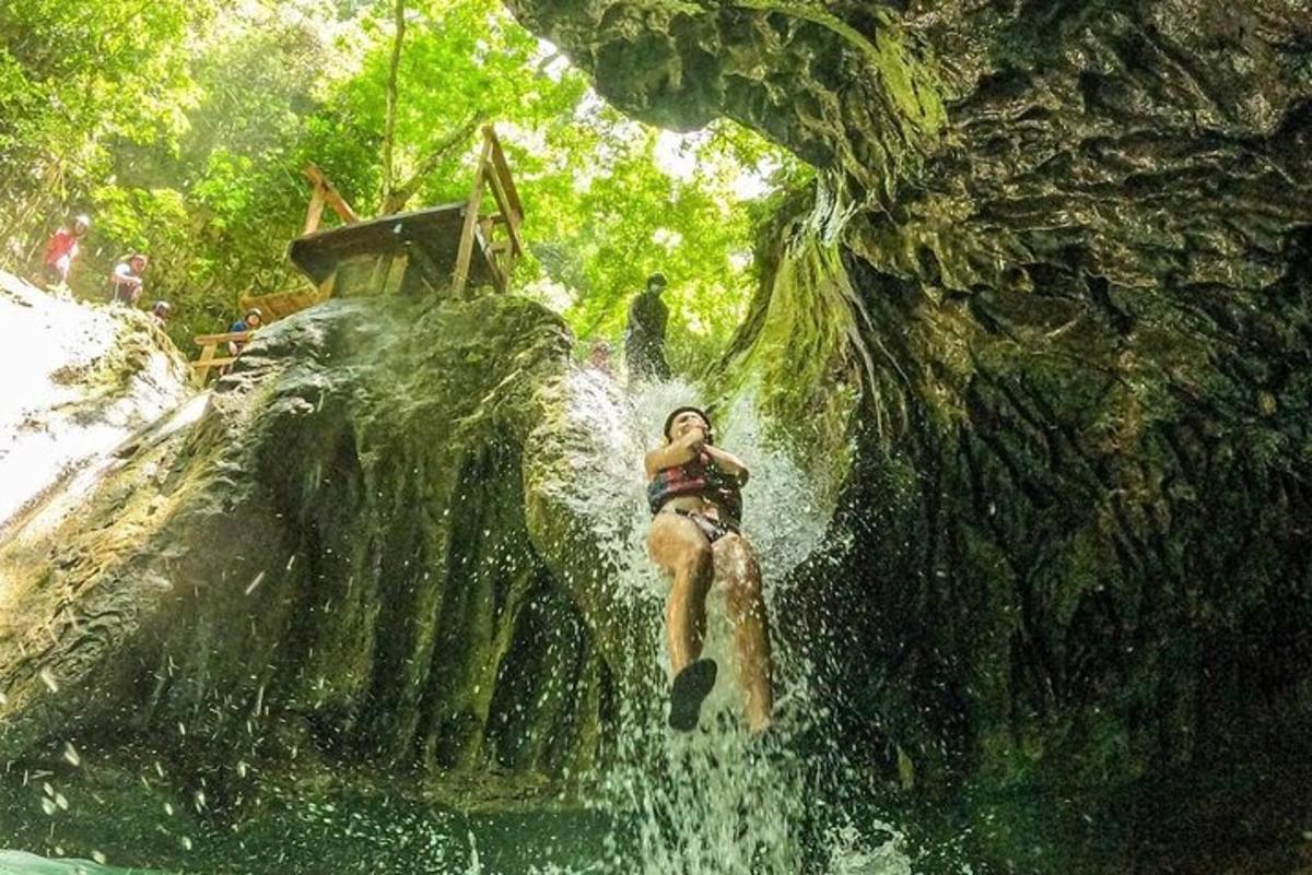 a woman is jumping into a waterfall in a fake waterfall