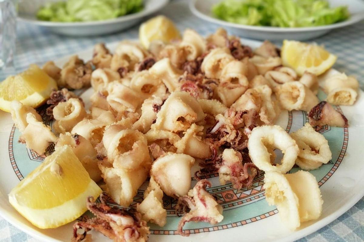 テーブルの上にエビとレモンが添えられた料理の皿