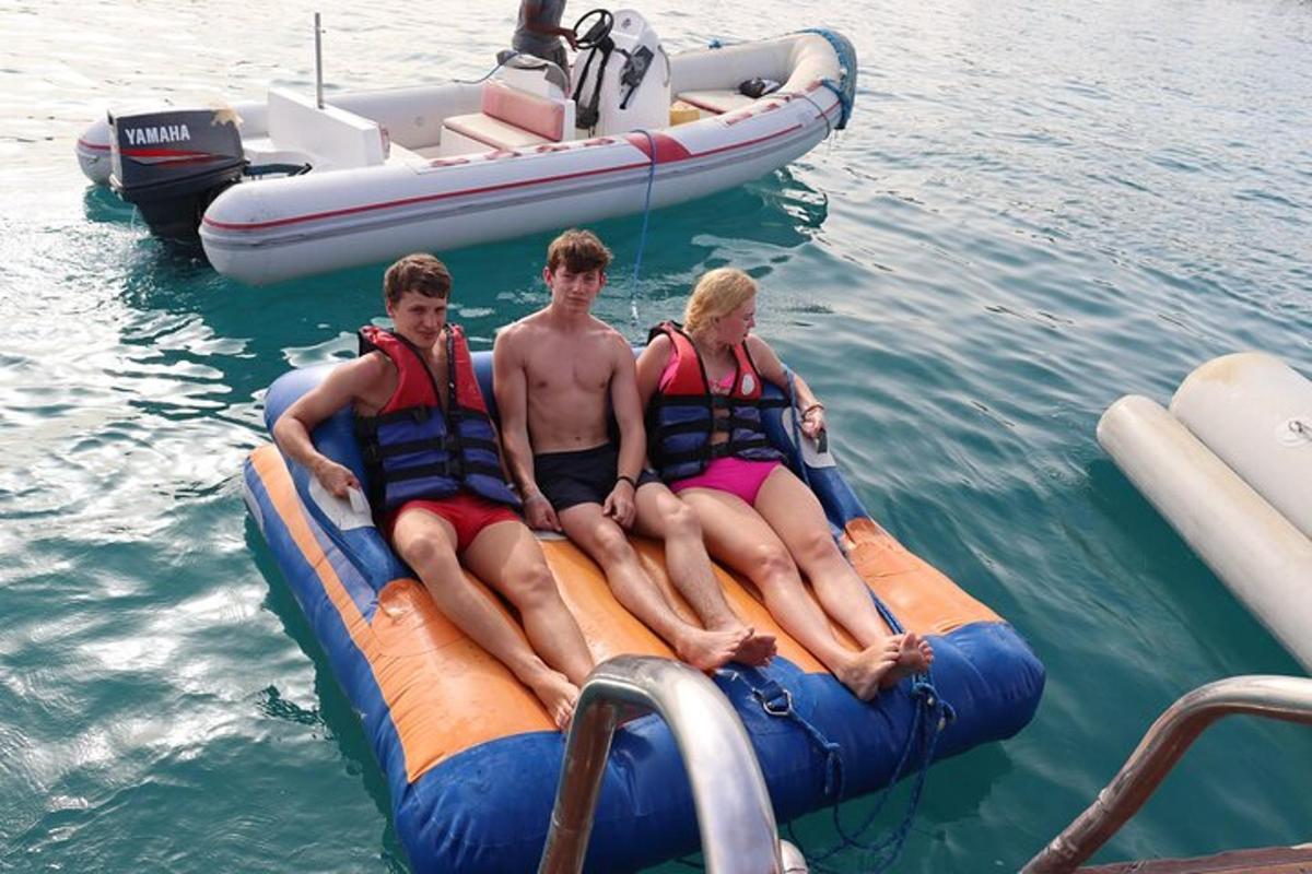 trije ljudje sedijo na splavu v vodi