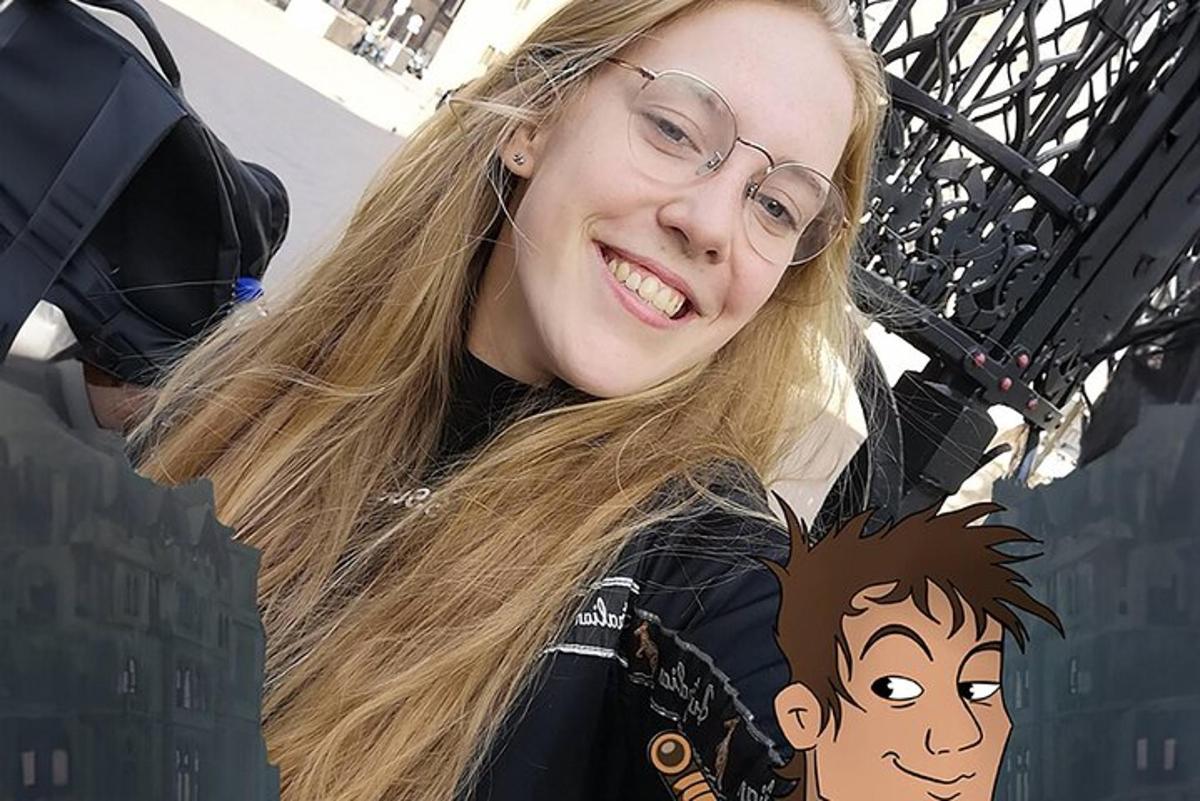 Mladá žena s brýlemi se usmívá do kamery