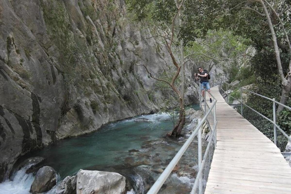 a man walking on a bridge over a river