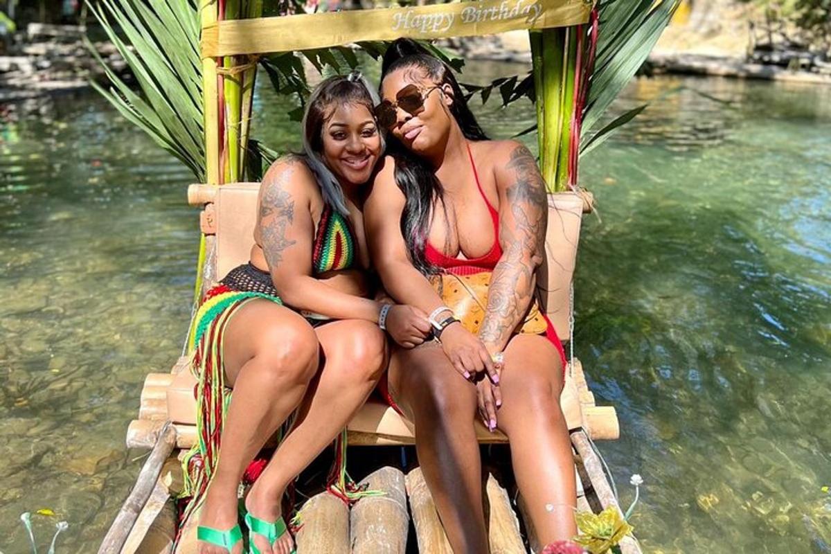 two women sitting on a bench in the water