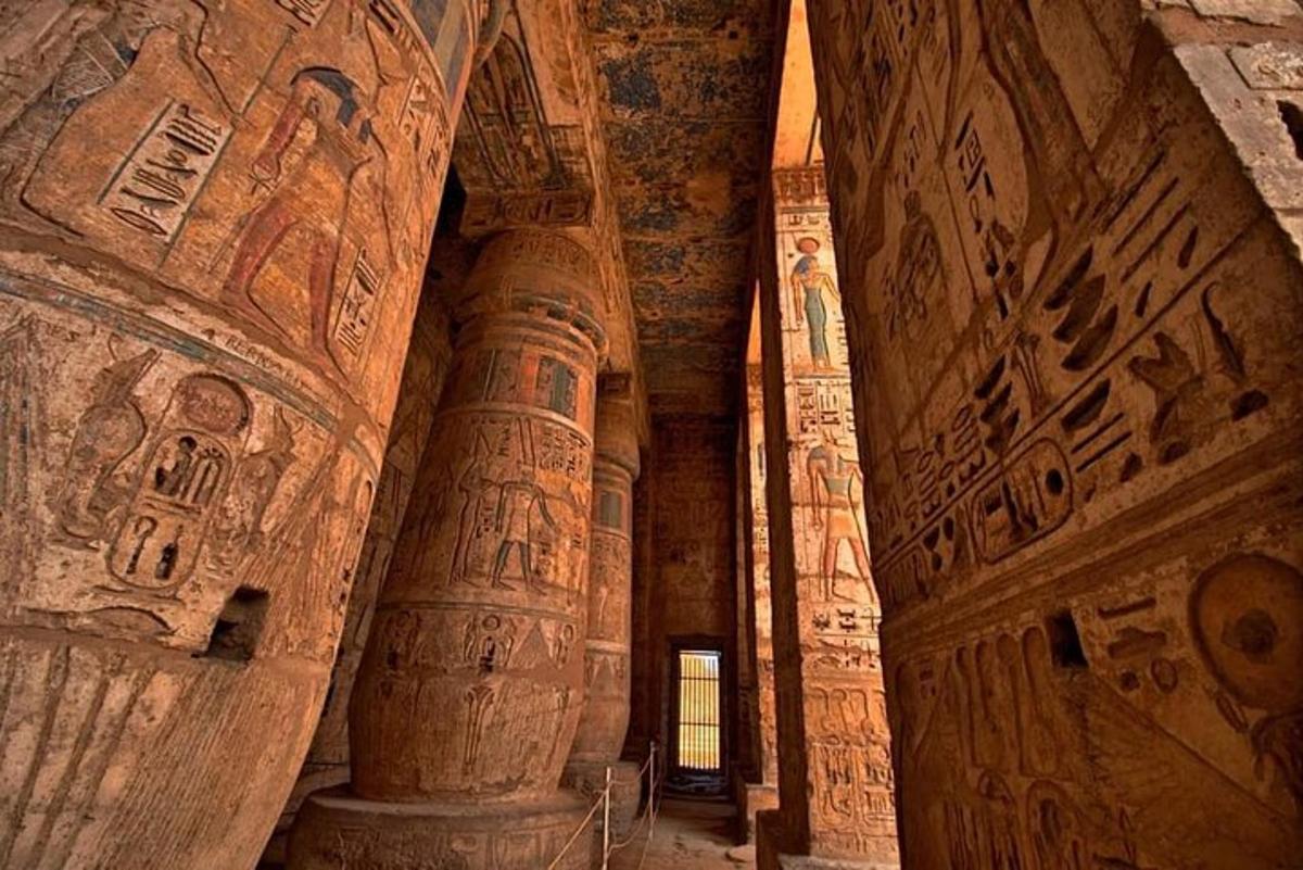 Un edificio antiguo con columnas y pinturas en las paredes.