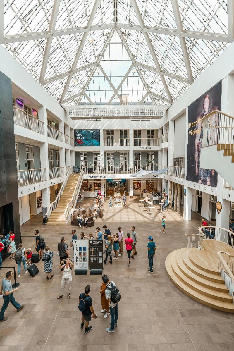 un grup de persones que passegen per un gran edifici