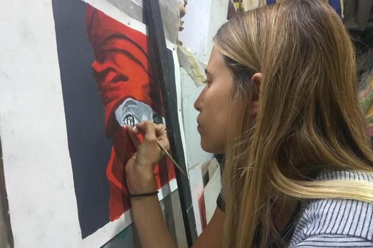 a woman is painting a painting on a wall