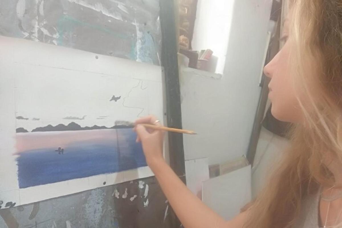 a woman is painting a picture on a wall