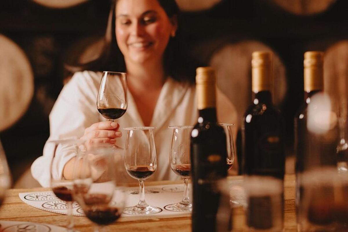 uma mulher sentada à mesa com taças de vinho